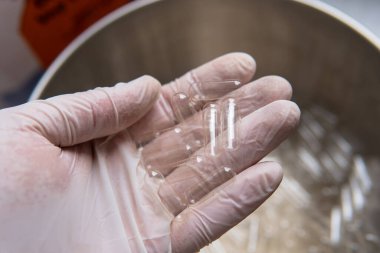 Kapsül dolum makinesi. Beslenme takviyeleri için şeffaf kapsüller. Kursların kapsül mikro dozlarının oluşturulması