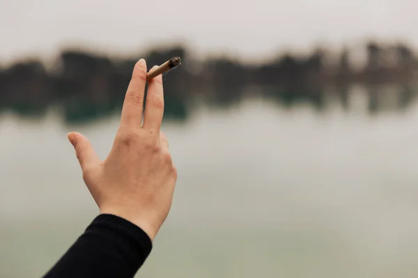 Mano Una Joven Sosteniendo Cigarrillo Marihuana Lago Aire Libre —  Fotos de Stock