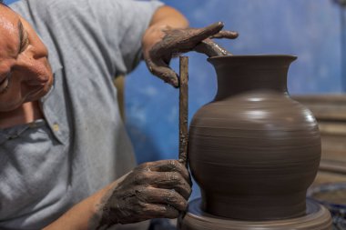 Talavera süreci için yapılmış vazoyu ölçen Meksikalı bir zanaatkar.