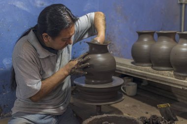 Meksikalı esnaf talavera işlemi için kil vazo yapıyor.