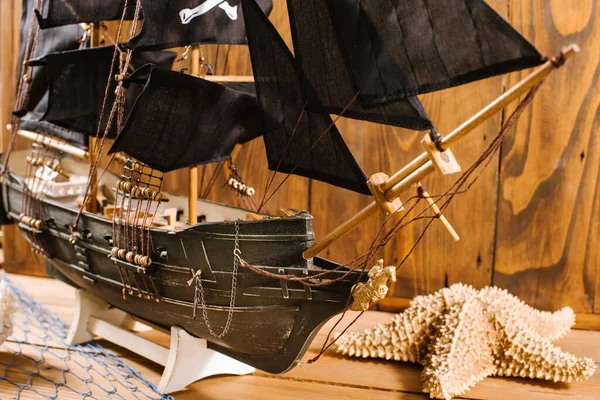 Model of old pirate ship on wooden background