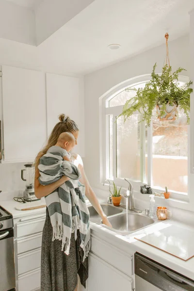 Мати Тримає Дитину Кухні Під Час Виконання Посуду — стокове фото
