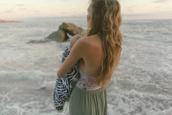 Мама Тримає Дитину Перед Пляжними Хвилями Під Час Заходу Сонця — стокове фото