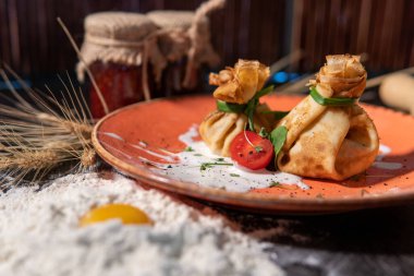 Peynir sosunun altında tavuk ve ıspanaklı krep.