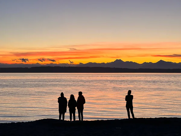 Silhouettes of People at Golden Gardens Along Puget Sound at Sunset