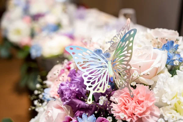 A metal butterfly is stopped on the flower displayed in Takasago