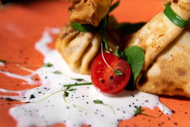 Peynir sosunun altında tavuk ve ıspanaklı krep.