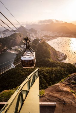 Sugar Loaf Dağı 'ndan Rio de Janeiro, Brezilya' daki şehir ve teleferiğe güzel bir gün batımı manzarası