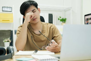 Hüsrana uğramış, sıradan kıyafetler giymiş, gözleri kapalı bir öğrenci...