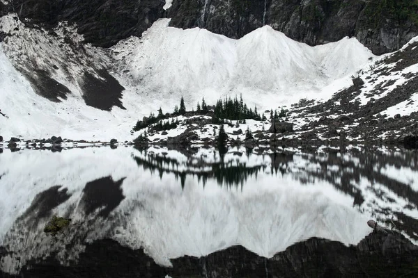 22 Gölü 'nün durgun sularına küçük bir tepe yansıdı. Washington Cascades' e kurulmuş küçük bir göl..