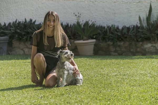 Yazın çimlerin üzerinde köpeğiyle poz veren genç Latin kız.