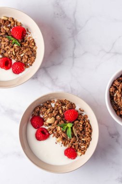 Yoğurtlu granola ve mermer arka planda bir kasede böğürtlen