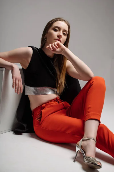 Kvinna Modell Klädd Röda Byxor Och Svart Jacka Poserar Studio — Stockfoto