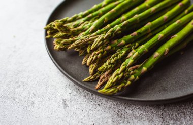 Gri tezgahtaki tabakta taze kuşkonmaz mızraklarını kapat..