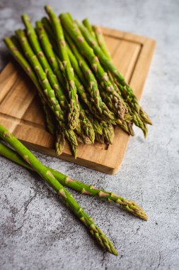 Tezgahtaki tahtayı keserken taze kuşkonmaz mızrağını kapat..