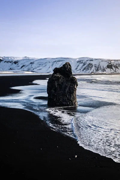 黒いビーチの真ん中にある巨大な岩 — ストック写真
