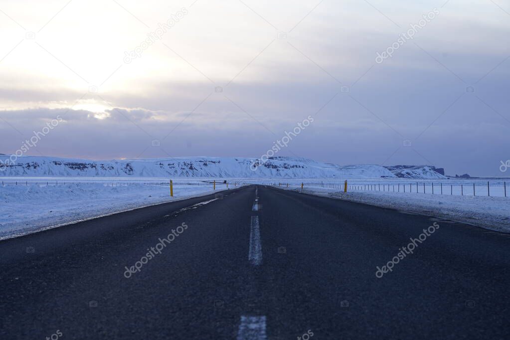 Asphalt road with snow-covered roadsides