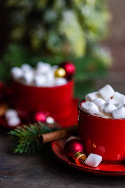 Noel yemeği konsepti olarak arka planda baharatlar olan mini marşmelovlarla dolu bardaklar.