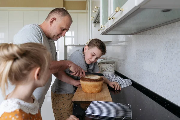 Een Vader Met Kinderen Snijdt Vers Zelfgemaakt Brood — Stockfoto