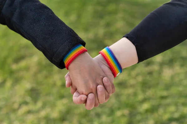 Två Lesbiska Flickvänner Som Håller Hand Och Bär Hbt Regnbågsarmband — Stockfoto