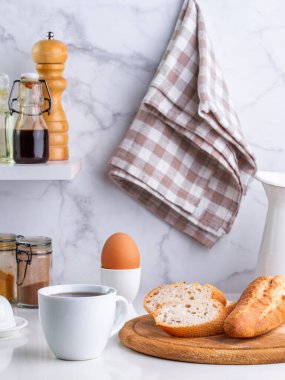 Ekmek, haşlanmış yumurta ve kahve mutfak masasında.