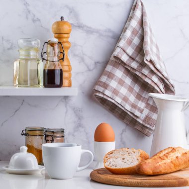 Ekmek, haşlanmış yumurta ve kahve mutfak masasında.