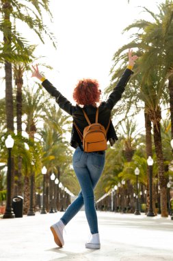 Kızıl saçlı genç Latin kadın tatillerini dışarıda geçirmekten memnun.