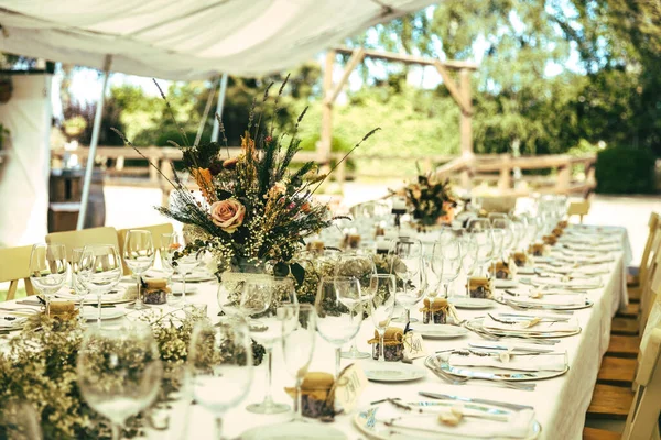 Long table set with candles, flowers, and table runner. Wedding table