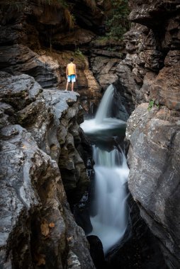 Chapada dos Veadeiros, Gois State, Orta Brezilya 'da şelaleli kayalık vadiye bakan adama güzel bir manzara 