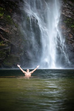 Büyük doğal şelalenin tadını çıkaran adama güzel bir manzara