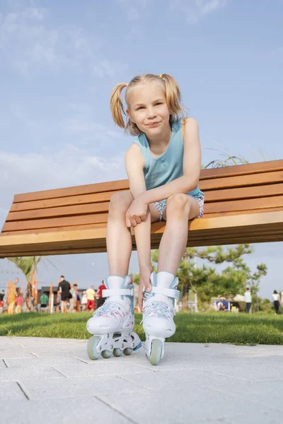 Girl Roller Skates Sits Park Bench Fastens Lock — Stockfoto