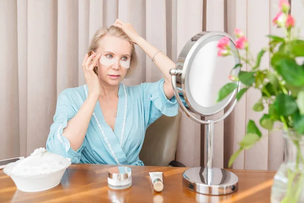 Een Volwassen Vrouw Gebruikt Een Cosmetisch Masker Onder Haar Ogen — Stockfoto