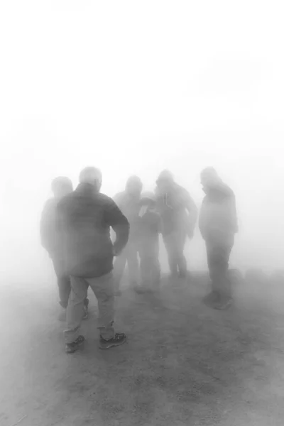 group of people together in heavy fog