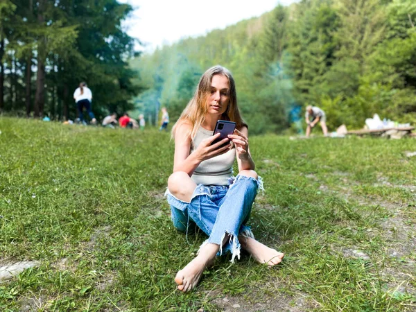 Girl Looks Phone Background Picnic — 图库照片