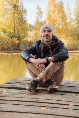 Sonbaharda ceketli, gülümseyen yakışıklı adam.