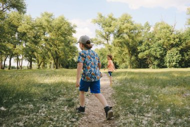 Çocuklar dışarıda oynuyor, yaz günü spor yapıyorlar.