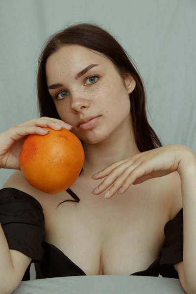Junge Frau Mit Sommersprossen Hält Grapefruit Der Hand Und Blickt — Stockfoto