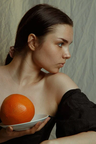 Young Woman Sideways Holding Grapefruit Plate — Stockfoto