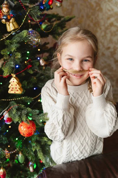 Portrait of a funny girl near the Christmas tree.