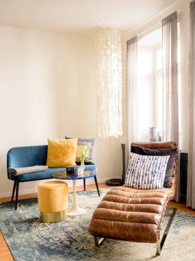 Sandalyeleri ve masası olan modern oturma odasının içinde.