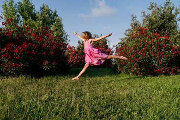 Girl Jumps Park Grass Oleander Bushes — Stok fotoğraf