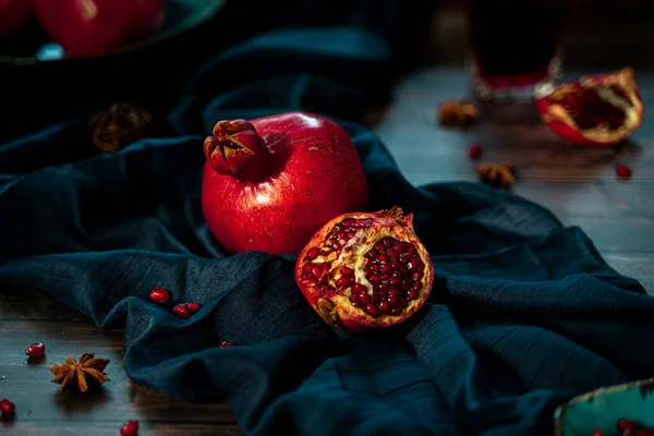 Pomegranate on a fabric runner on a dark table