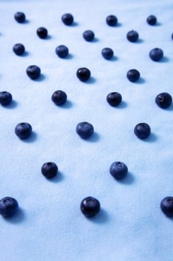 Vertical photo with pattern of blueberries on a blue field