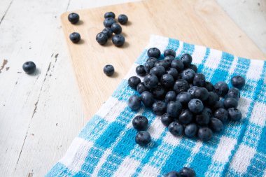 Blueberries on a napkin with a checkered pattern on a wooden table