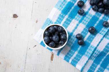 Top view of blueberries in a small bowl on a wooden table