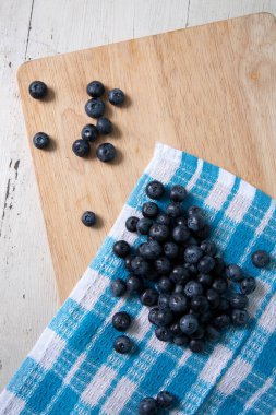 Top view of blueberries on wooden cutting board. Vertical photo