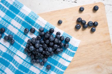 Top view of blueberries on wooden cutting board