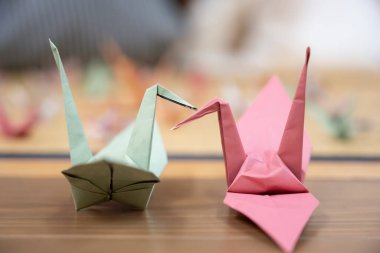 Two origami cranes that stick the beaks together