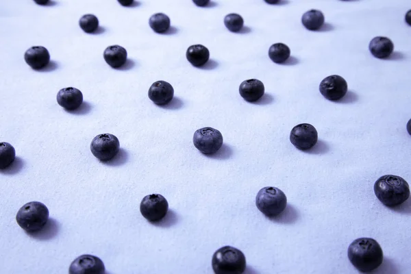 Pattern of blueberries on a lilac field