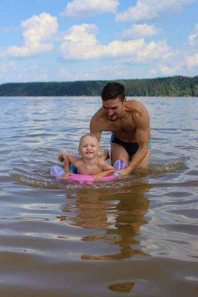 Father teaches son to swim